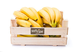 In einer Holzkiste mit Softripe Logo liegen Bananen